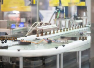 Massachusetts suspende la fabricación de cannabis de MRM Industries Una línea automatizada transporta pequeños frascos de vidrio ámbar en una instalación de fabricación