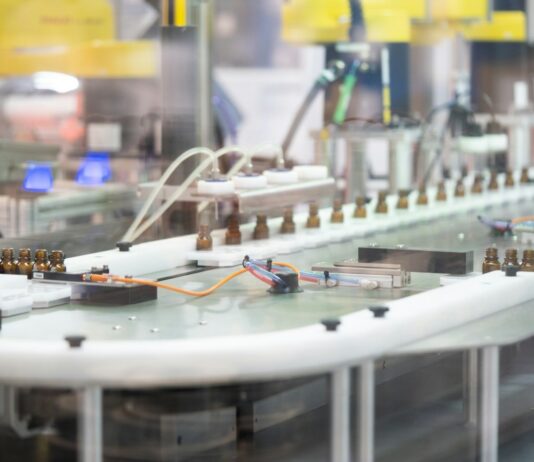 Massachusetts suspende la fabricación de cannabis de MRM Industries Una línea automatizada transporta pequeños frascos de vidrio ámbar en una instalación de fabricación