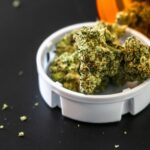 Flores de cannabis medicinal en un envase de prescripcion sobre fondo oscuro