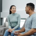 Profesional sanitario conversa con una paciente durante una consulta clinica