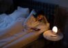 Cannabis e insomnio en Reino Unido: un registro observa mejoras a dos años Una mujer mira el móvil en la cama, con la habitación iluminada por una lámpara